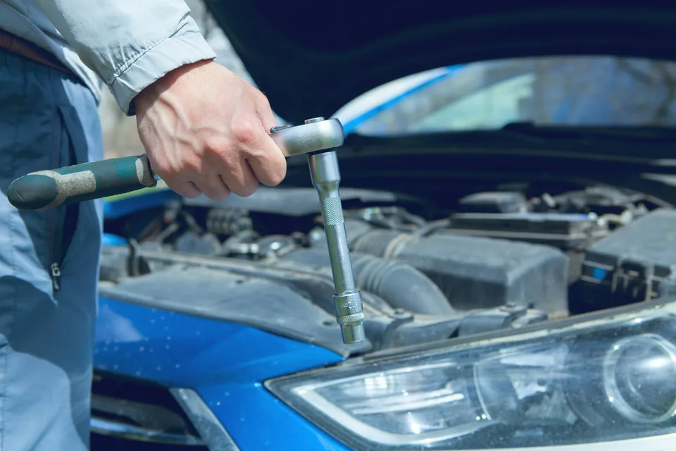 Arbeit mit einem Steckschlüssel am Motor, Symbolfoto